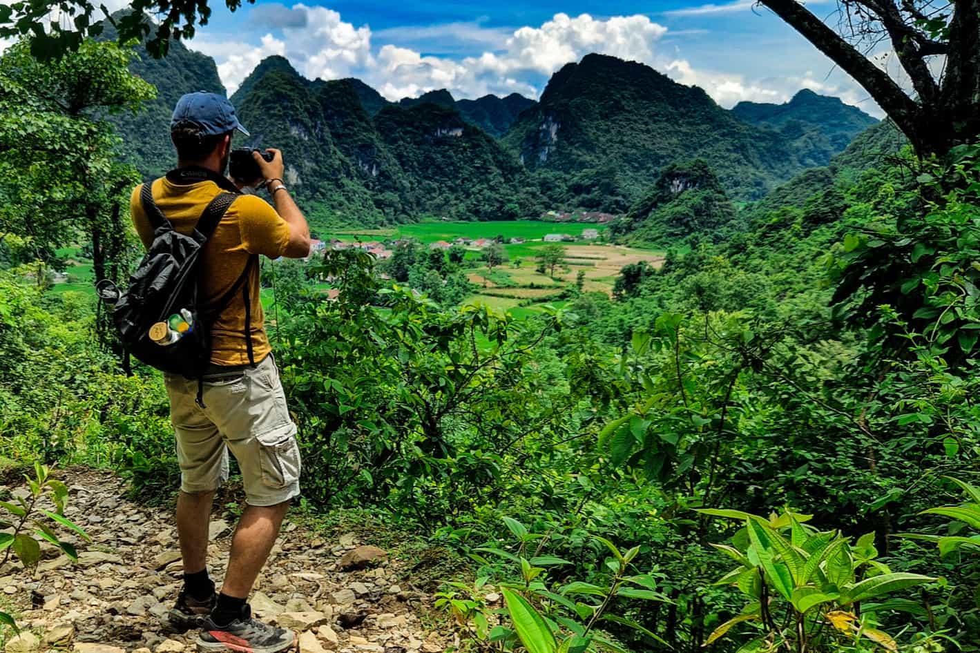 HOST - Hiker taking a photo of the dramatic landscape of Cao Bang in the north of Vietnam. Photo: Host/Easia Active