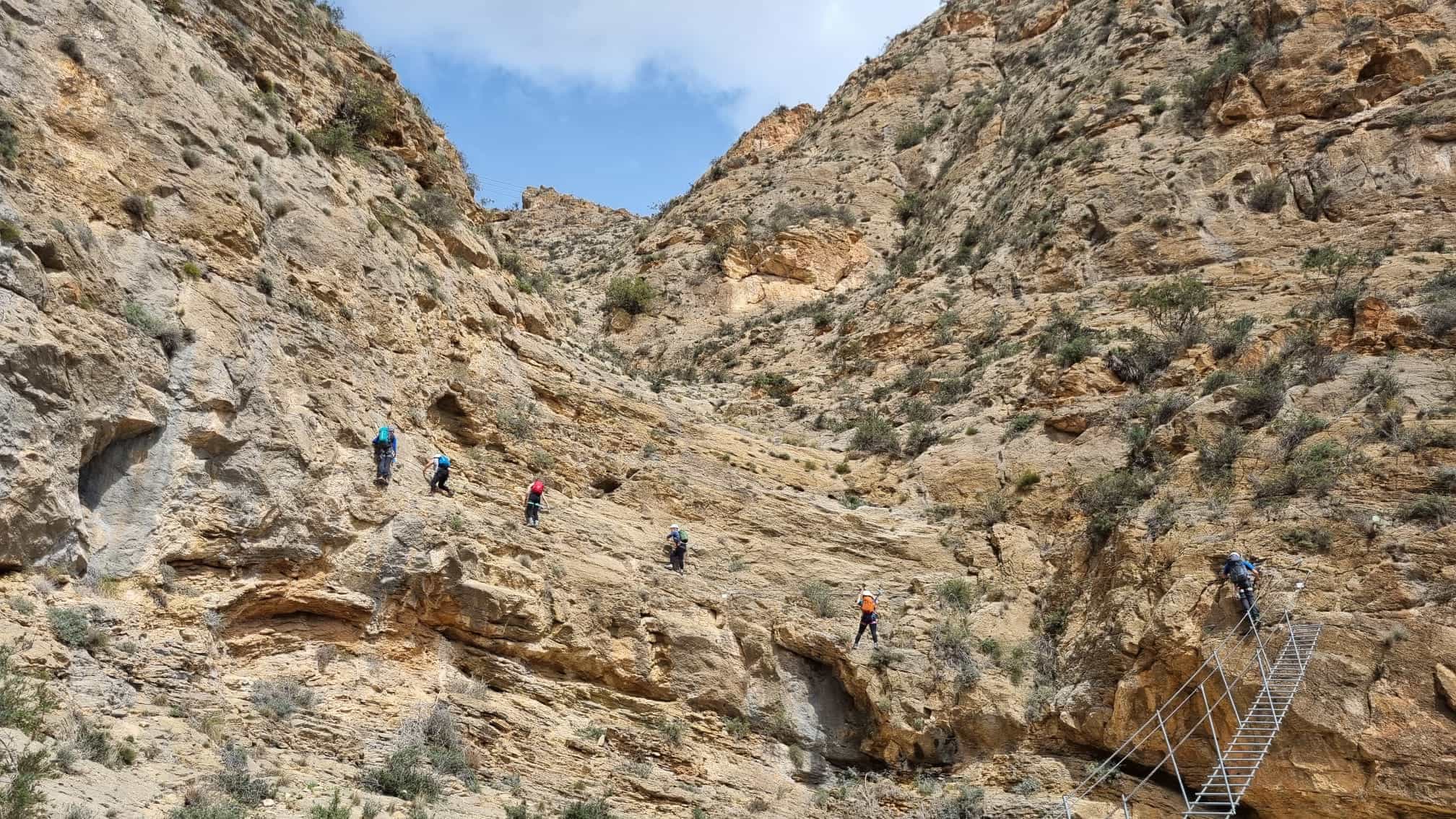 Group of climbers traversing a via ferrata in Spain.