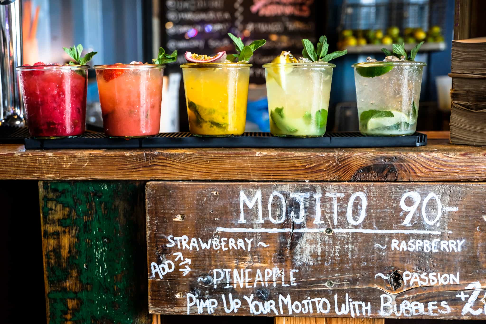 Tropical colorful mojito at a wooden bar, Cuba