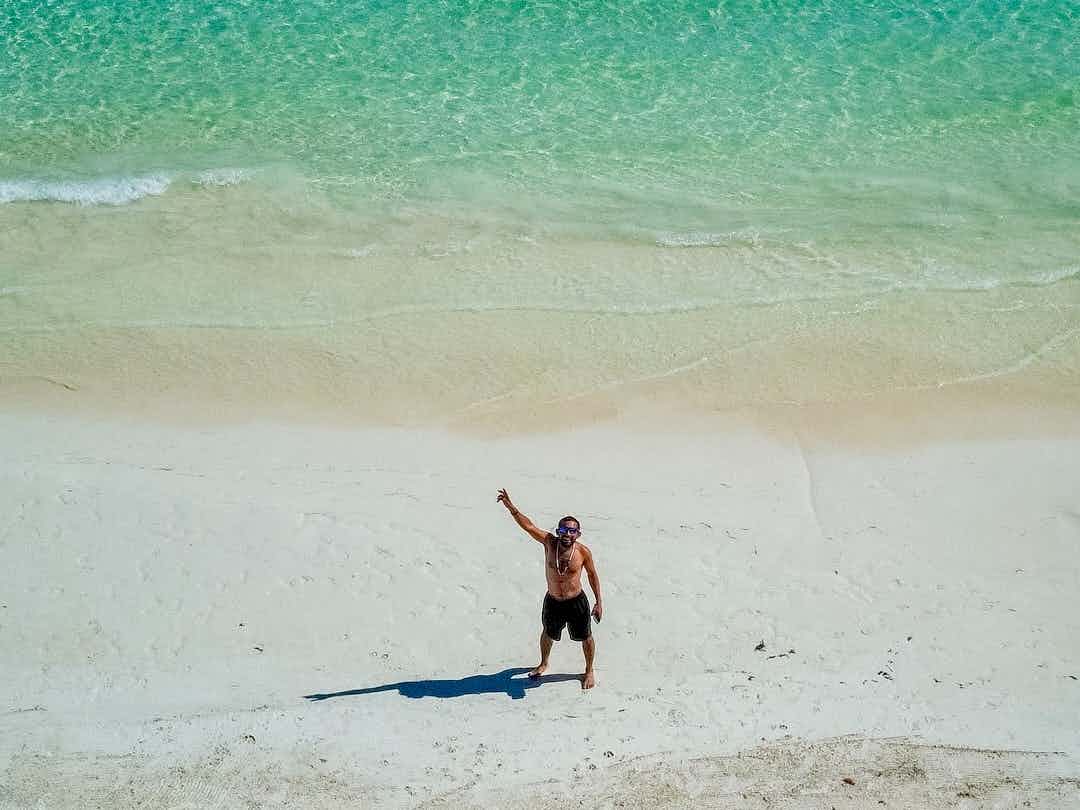Tourist waving from a beach in Mexico.