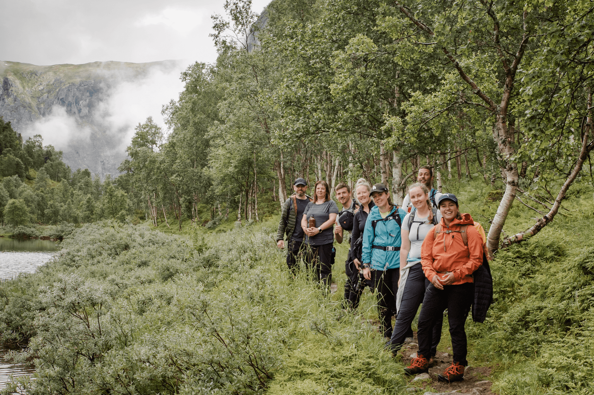 A happy group of hikers on the edge of the Naeroyfjord in the Norwegian Fjords.