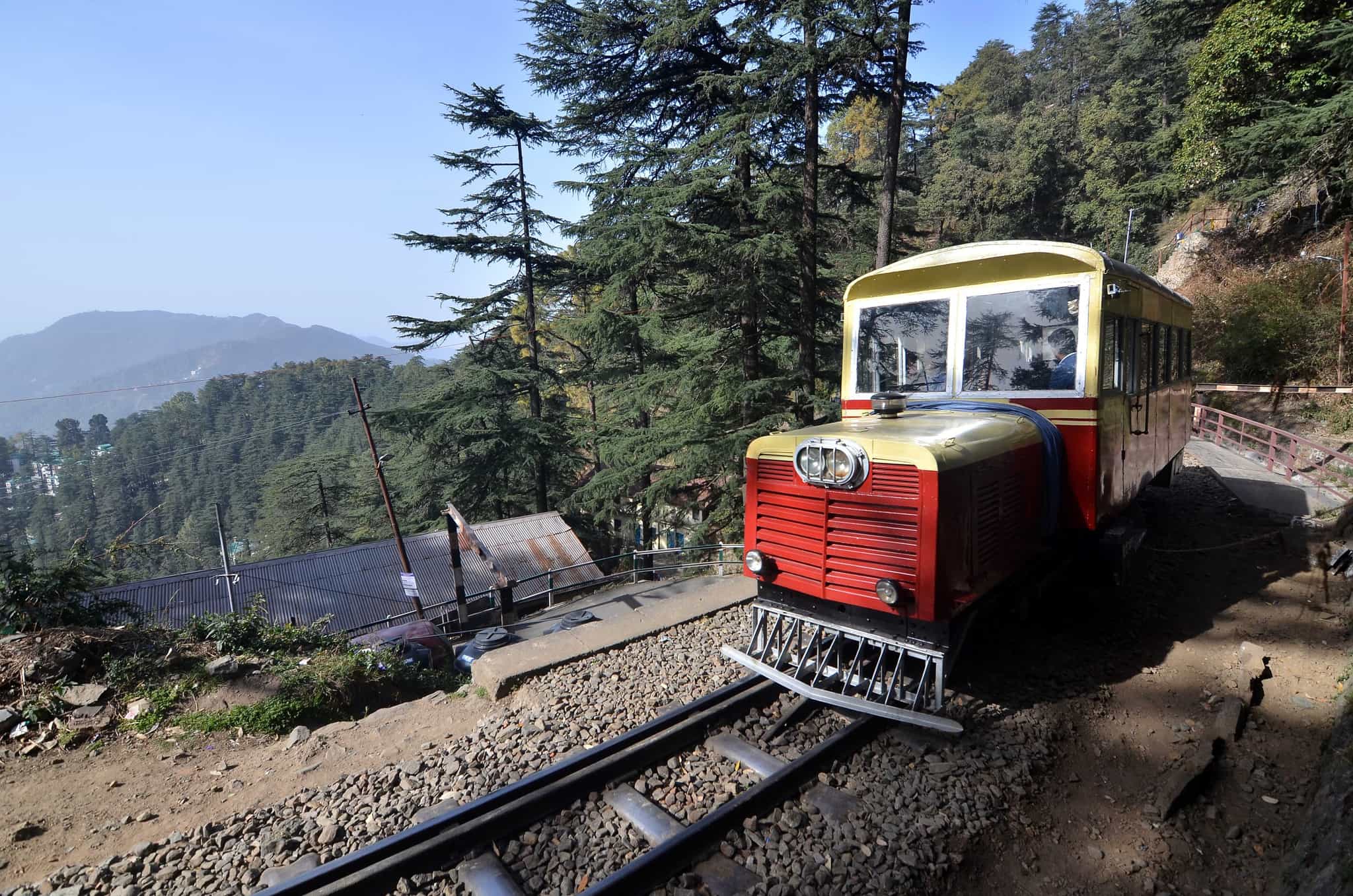 Heritage 'toy train' on the track in the forest with mountain views in the background
