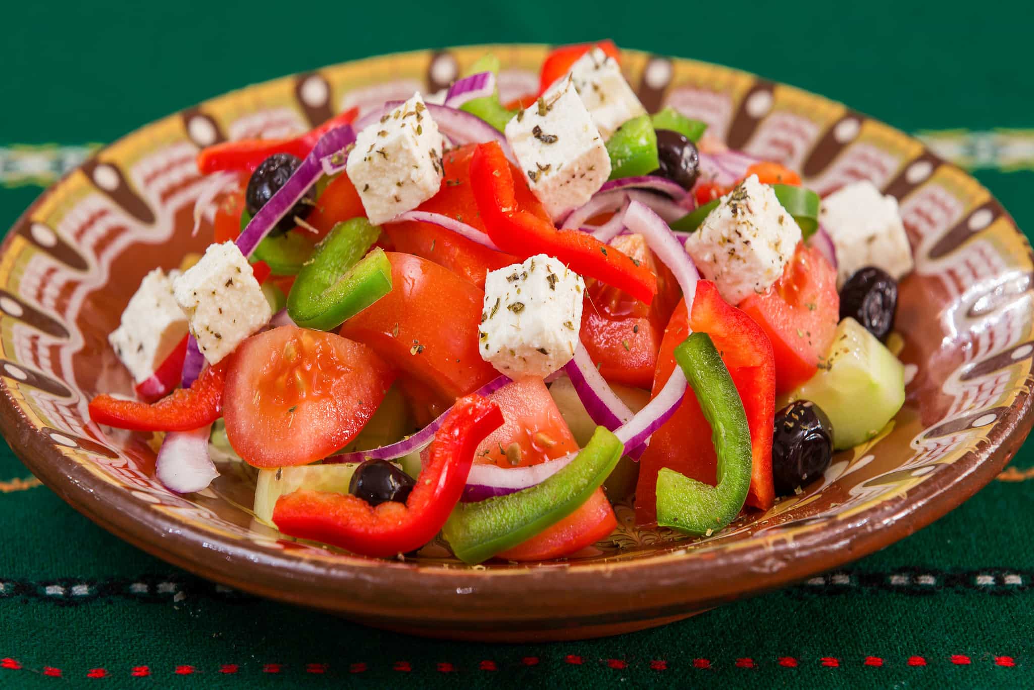 A Greek salad with feta cheese on top.