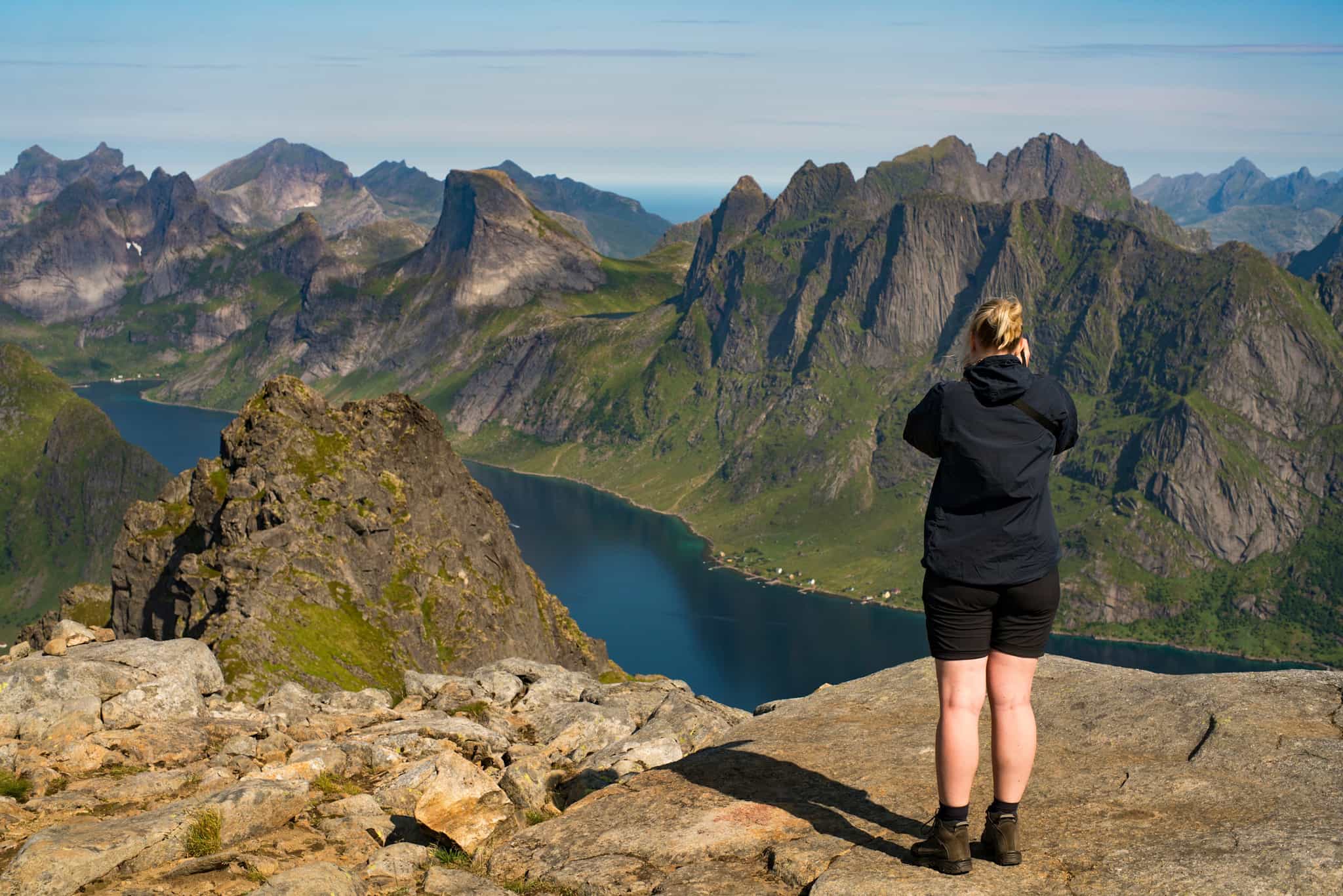 Hiker overlooking Munken in the Lofoten Islands, Norway.