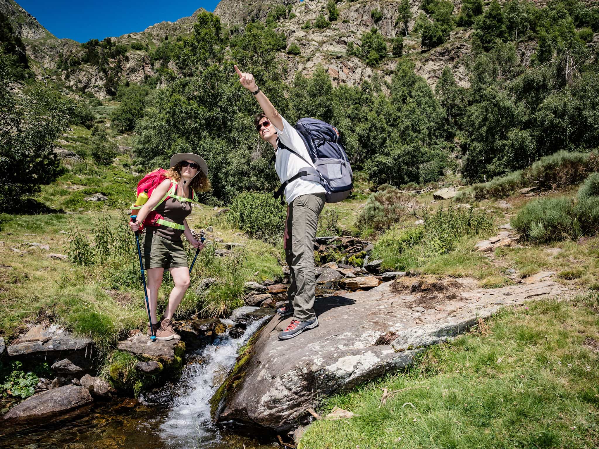 Hikers crossing a stream in the Pyrenees