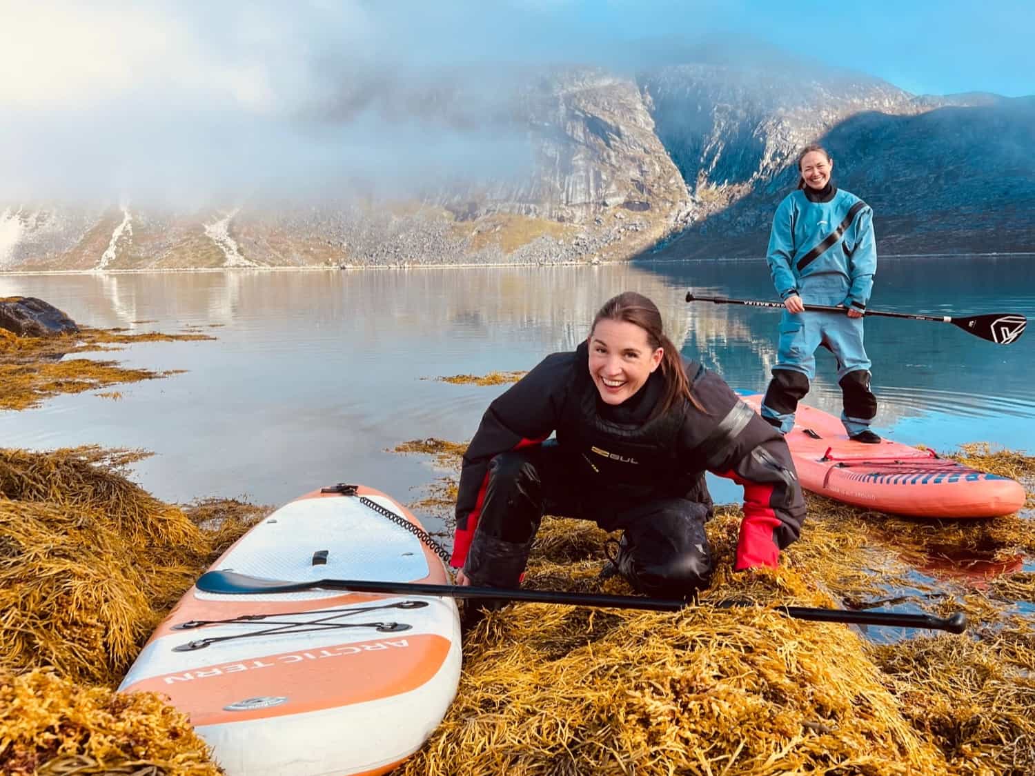 Two adventurers paddleboarding in Greenland