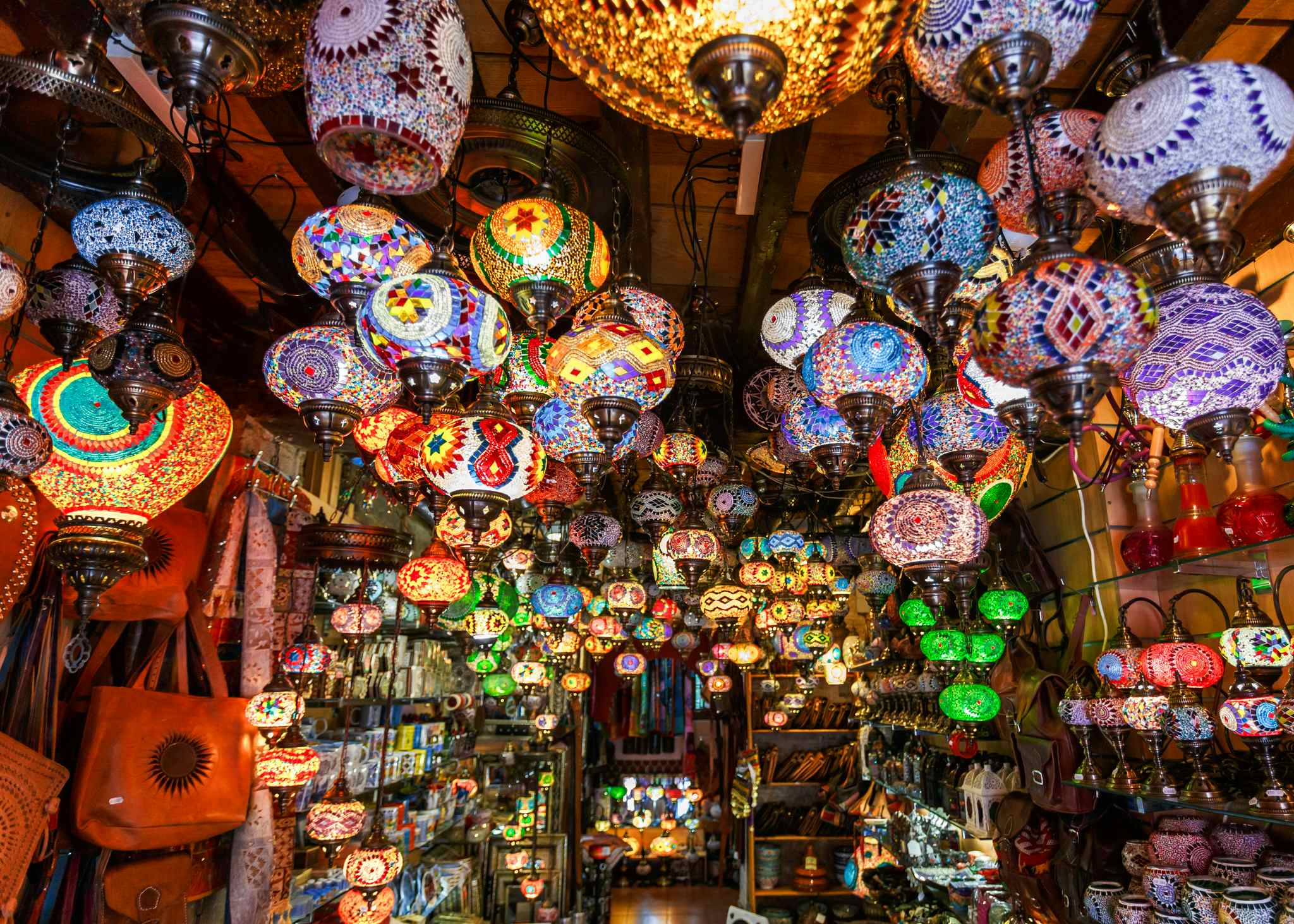 Colourful lights and lanterns hang from the ceiling of a souk in Morocco. 