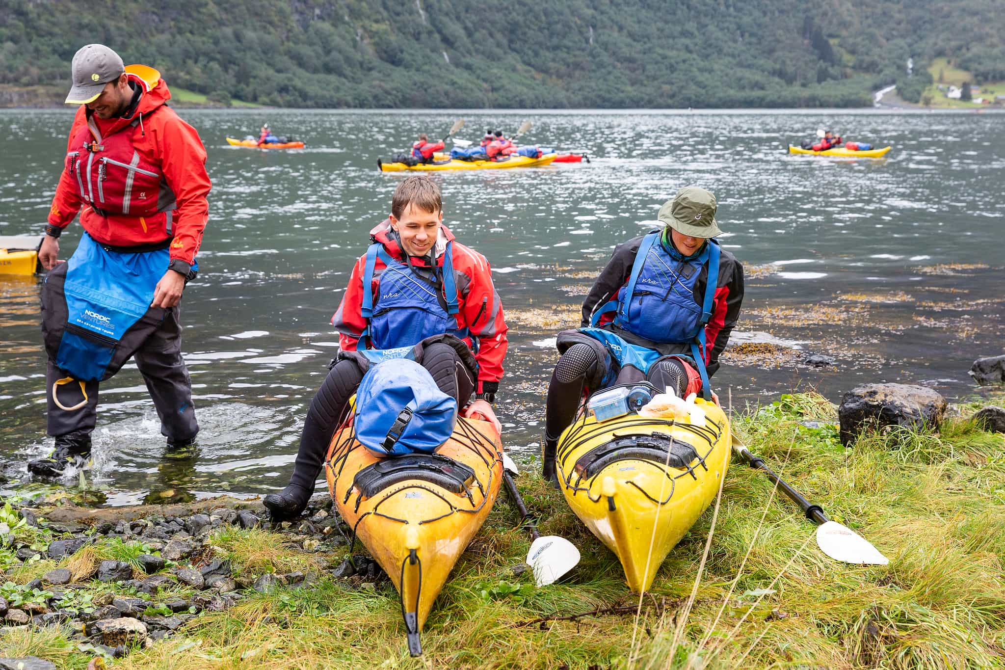 Two kayakers dismounting their kayaks on the edge if the Naeroyfjord in the Norwegian Fjords.