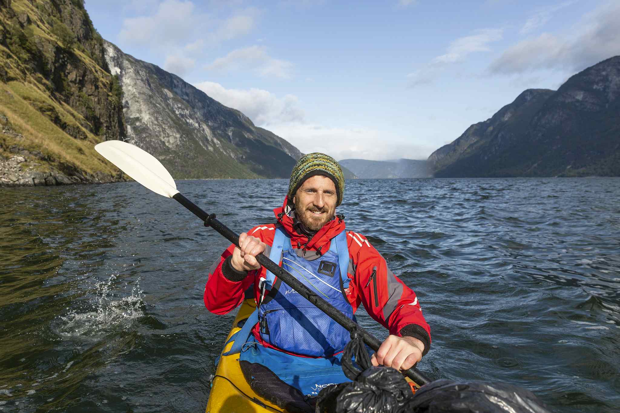 A kayaker paddling along the Nærøyfjord in Norway.