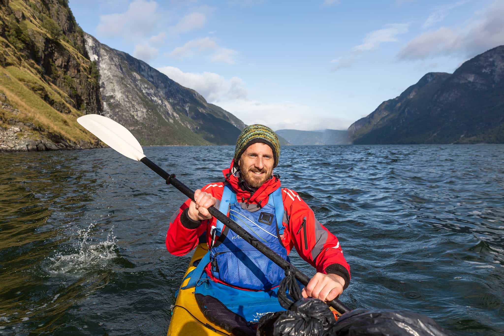 A kayaker paddling along the Nærøyfjord in Norway.