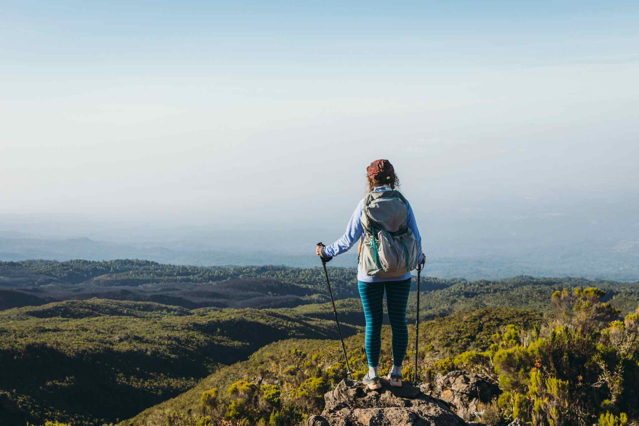 Female hiker overlooking view of Mount Kilimanjaro's forest zone in Tanzania.