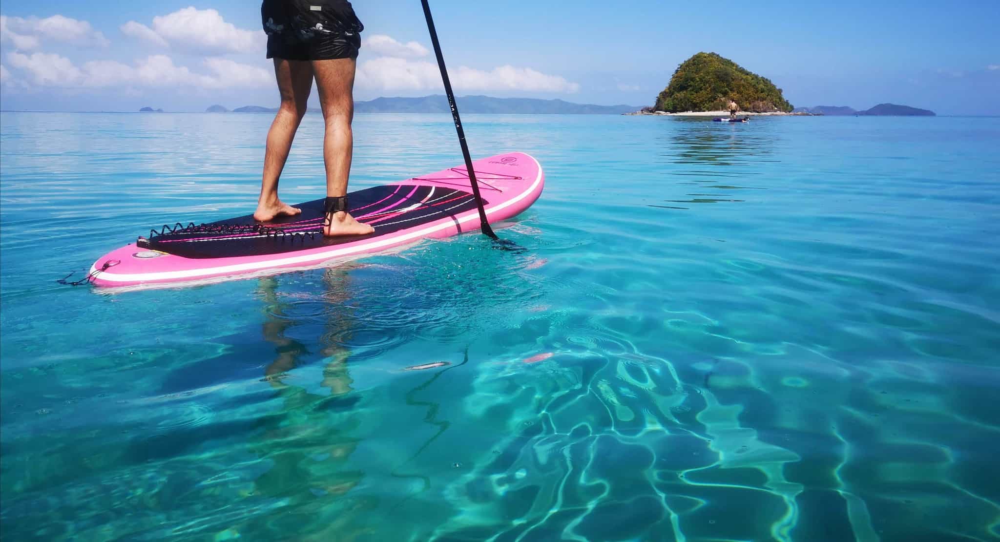 Man standing on a standup paddleboard on bright blue water