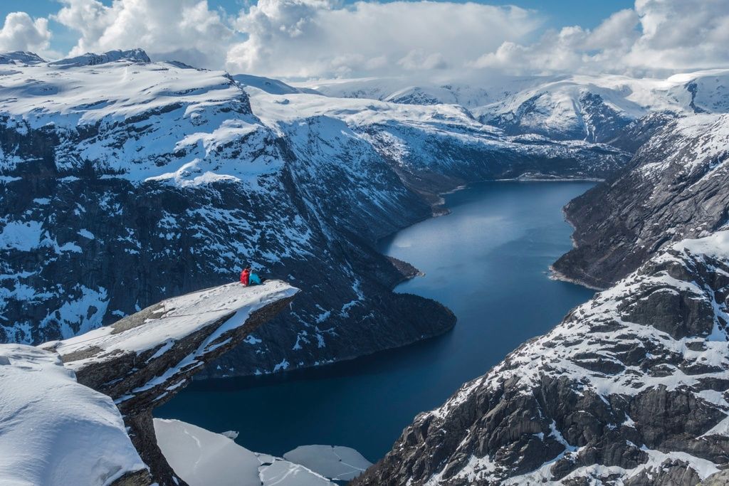 Two hikers perch on the 'tongue' of Trolltunga in winter