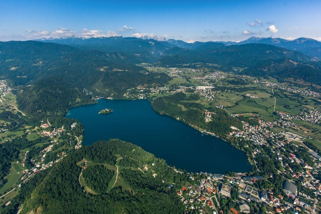 An aerial view of Lake Bled and the surrounding mountains and valleys.