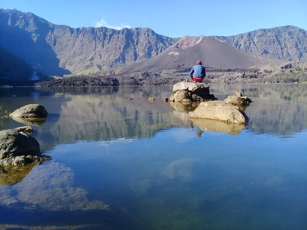 Looking out over a mountain lake while trekking on Mt. Rinjani, Indonesia