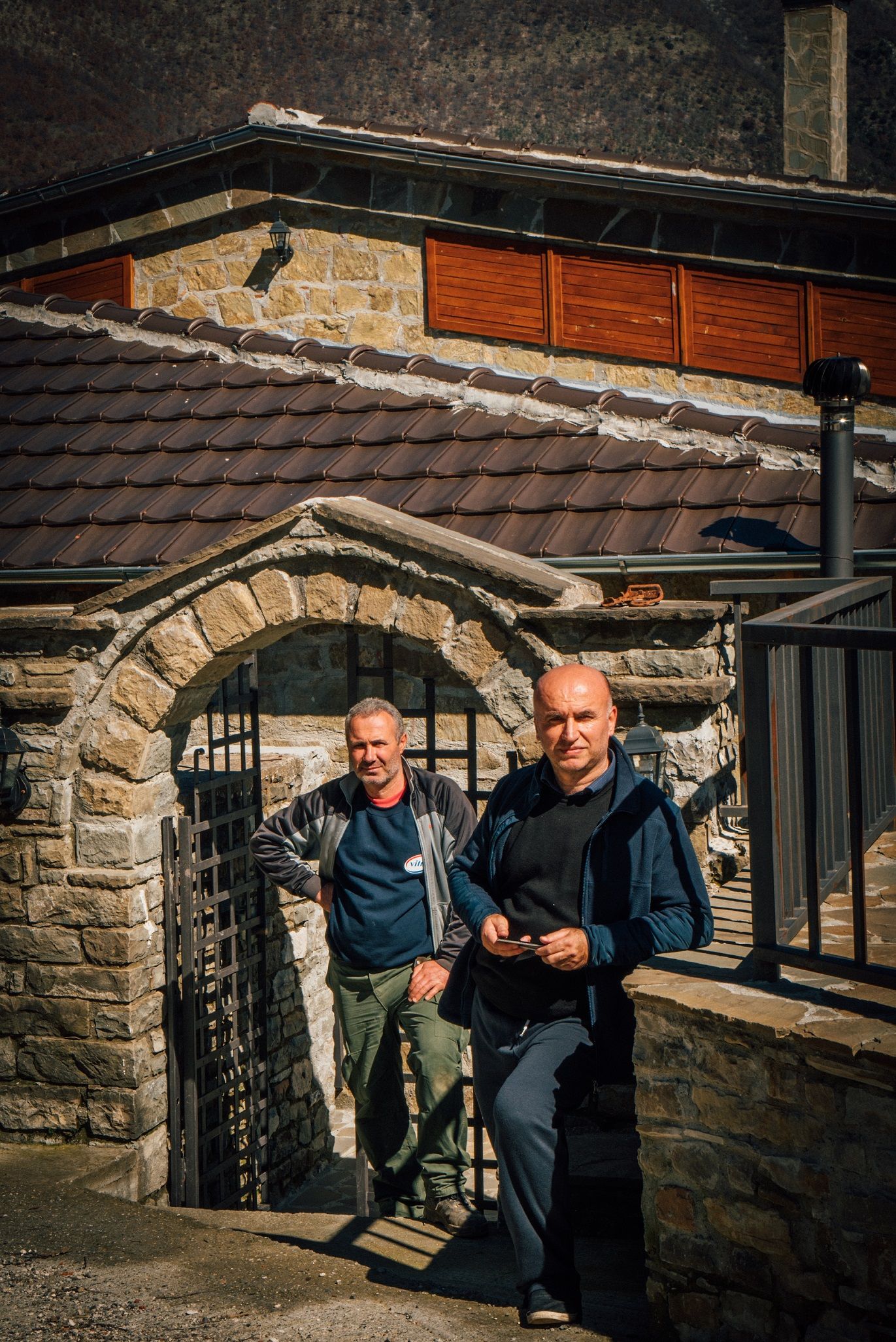 Mero Baze, an Albanian journalist, posing outside his home