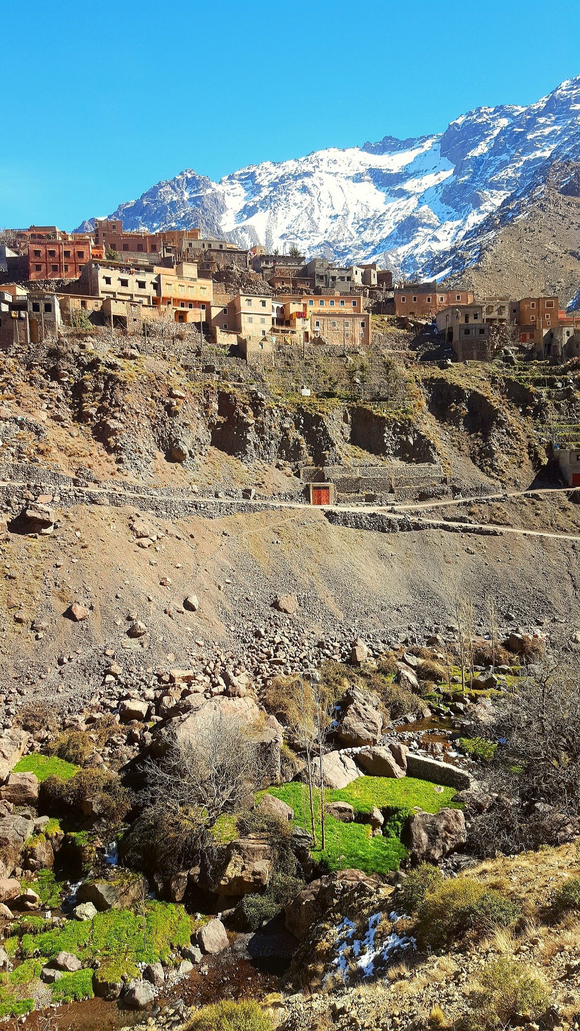 The Atlas Mountains in the backdrop, behind a layering Moroccan mountain town.