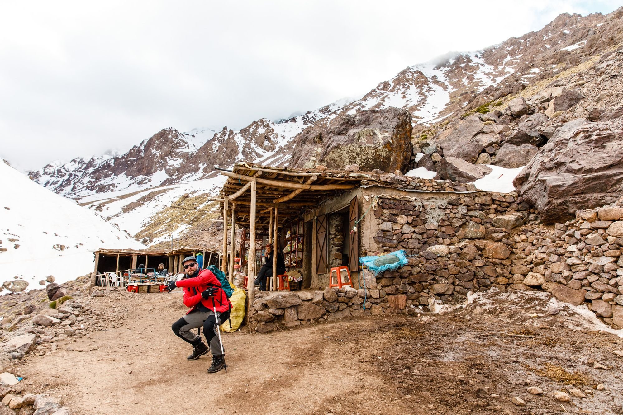 A hiker poses in front of the basecamp at Imlil, on the way up Mount Toubkal.