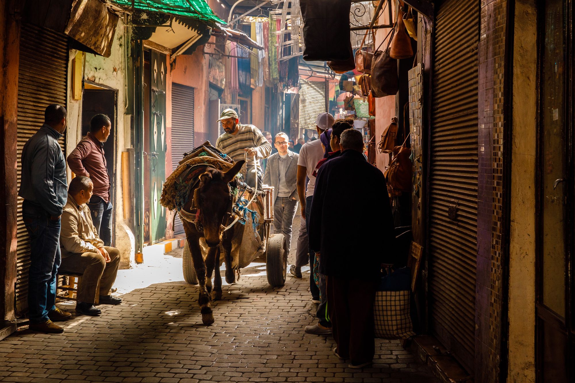 A man rides a donkey cart through a dim lit street in Imlil, Morocco