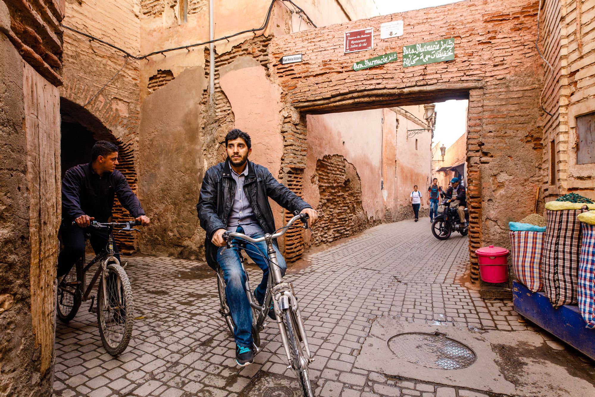 Two men cycle through the streets of Imlil, Morocco.