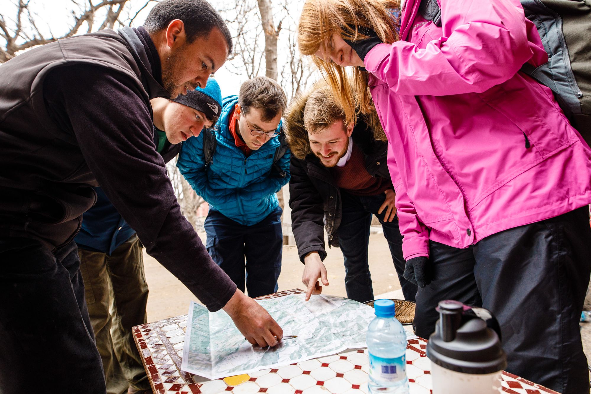 A group of hikers pore over a map.