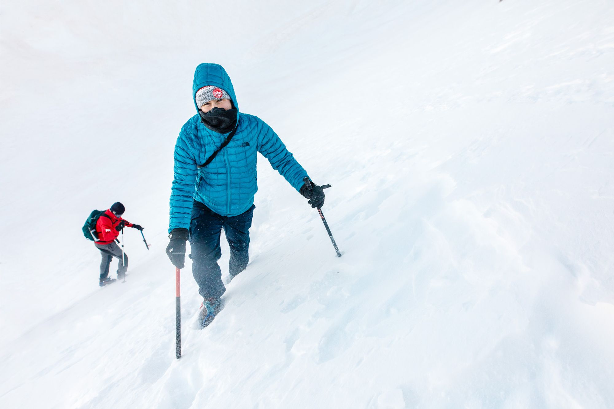 Climbing snowy Mount Toubkal with walking poles.