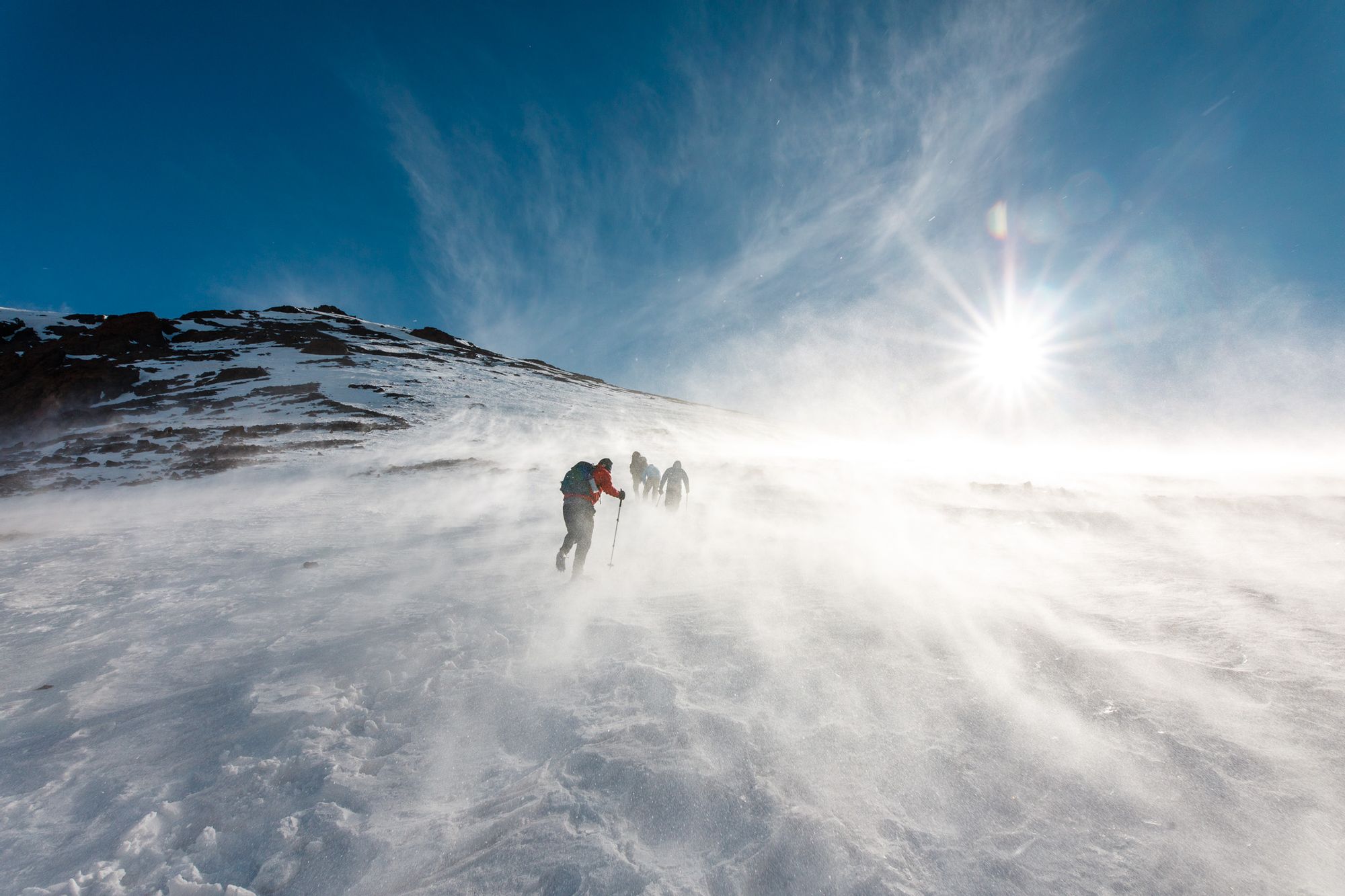 A hiking group summits Mount Toubkal in the snow.