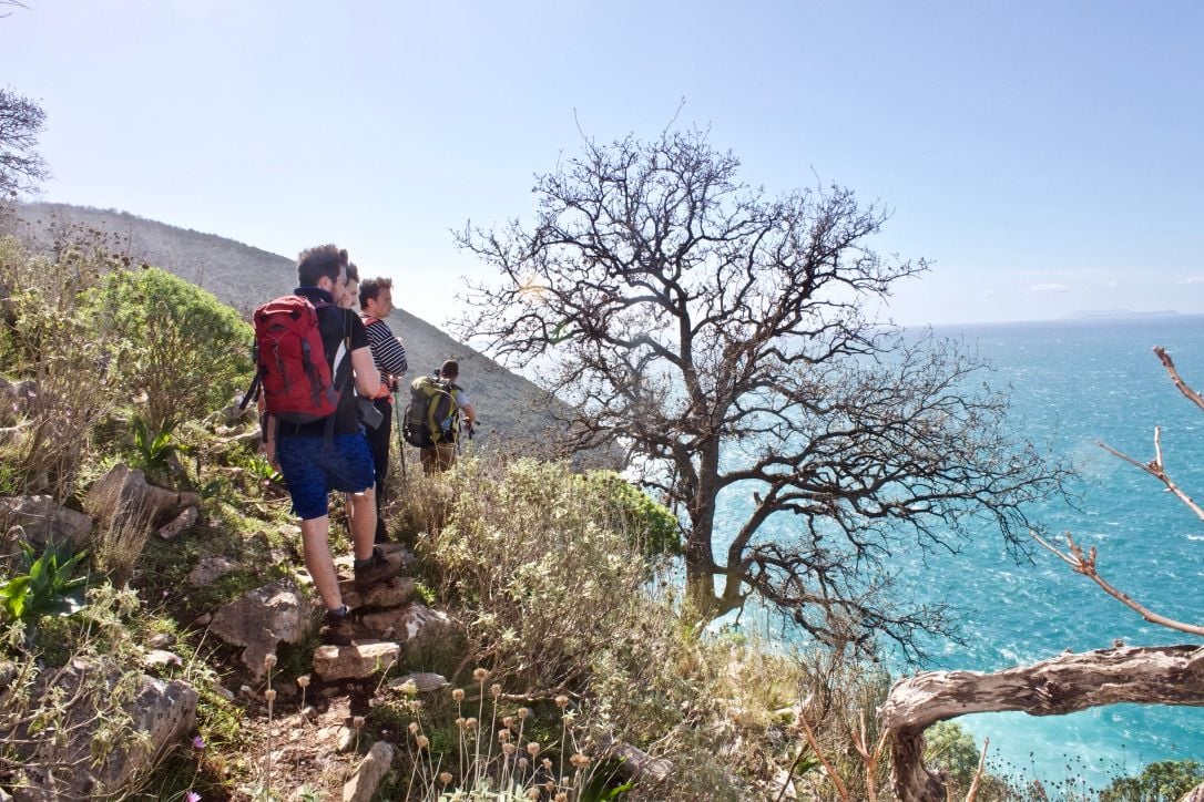 Hiking on a cliff-side trail in Albania, looking out onto the sea.