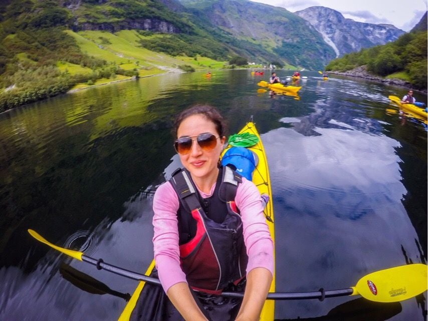 A woman takes a selfie while kayaking on a fjord in Norway.