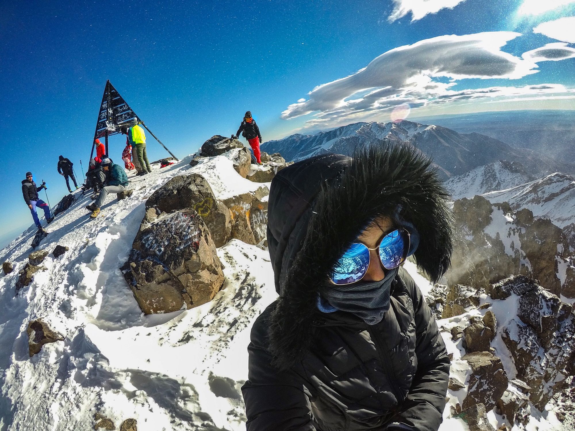 A woman takes a selfie at the top of Mount Toubkal.