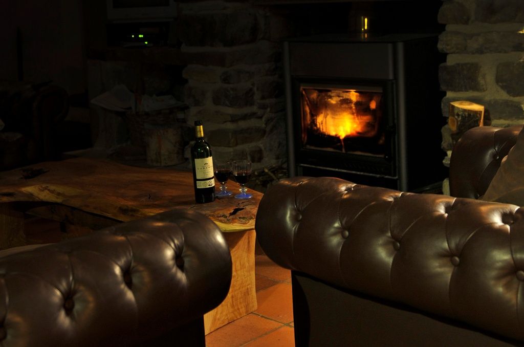 Chalet fireplace Two glasses of wine by the fireplace in a chalet in France.