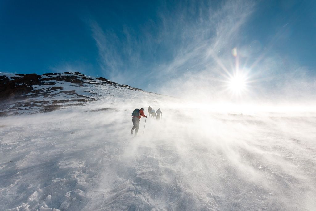 Hikers walking through a snow storm in Morocco's Atlas Mountains