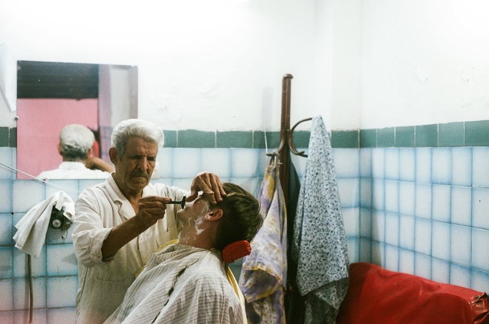 A barber shaving a man in Marrakech, Morocco