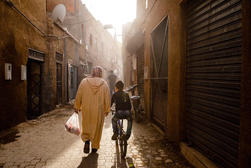 A woman and her son walking down a narrow street in Marrakech Morocco