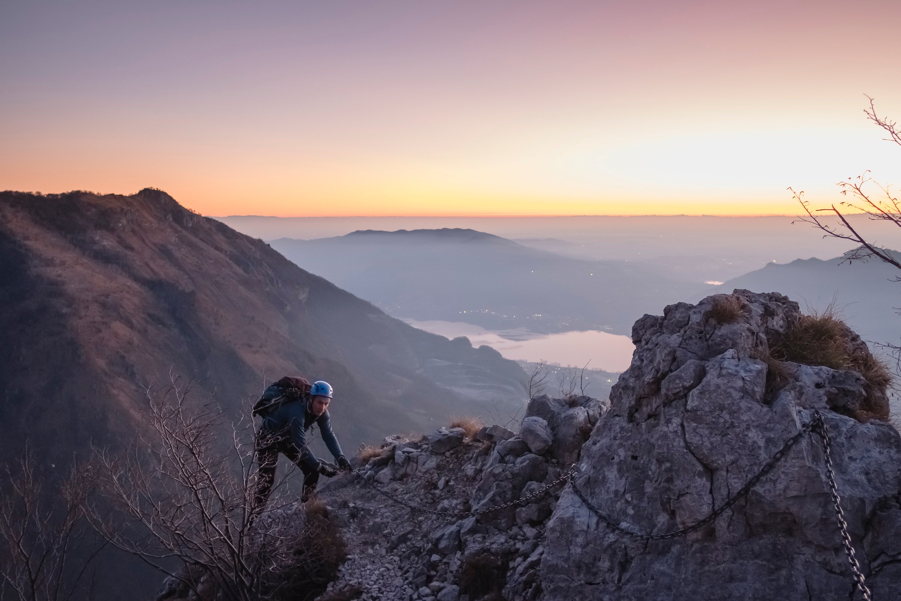 A hiker climbing a via ferrata above Lake Como, Italy