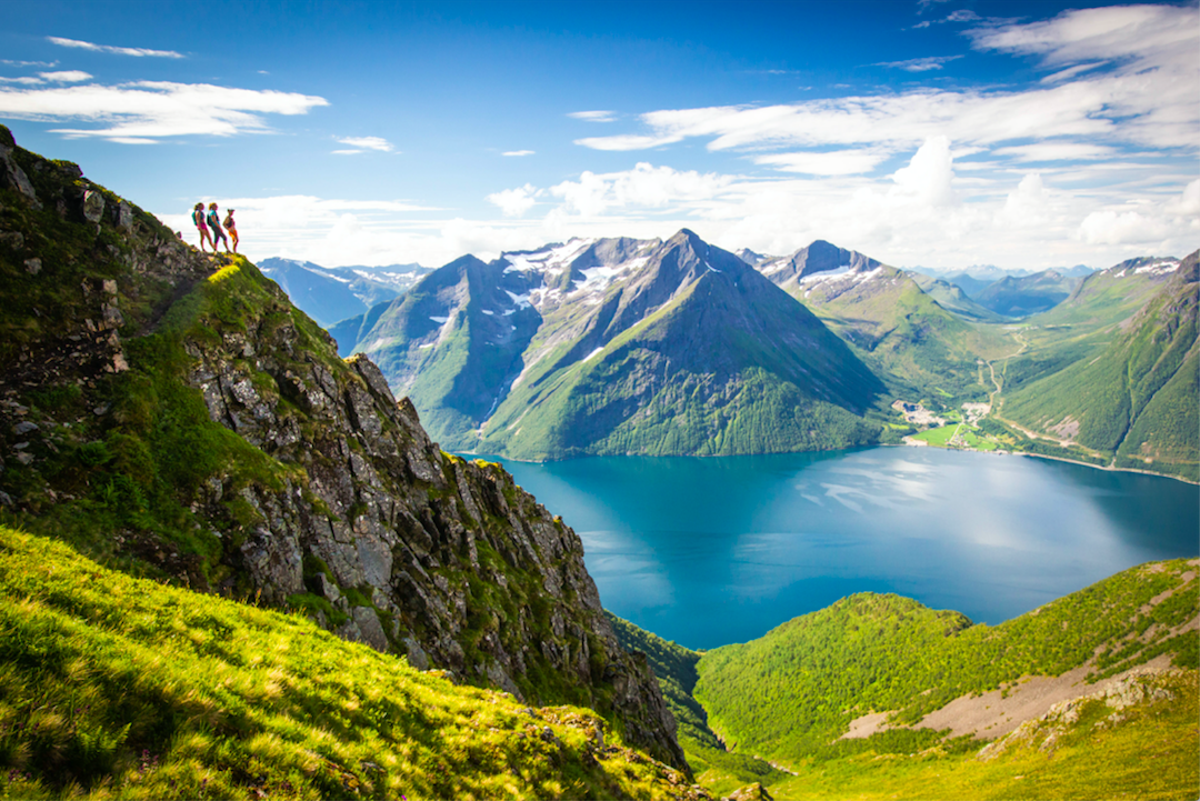 A group of hikers looking down over the Norwegian fjords.