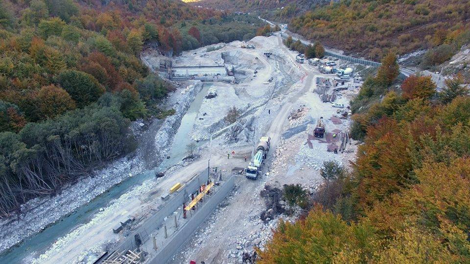 Construction lorries and site on the banks of the Vjosa River