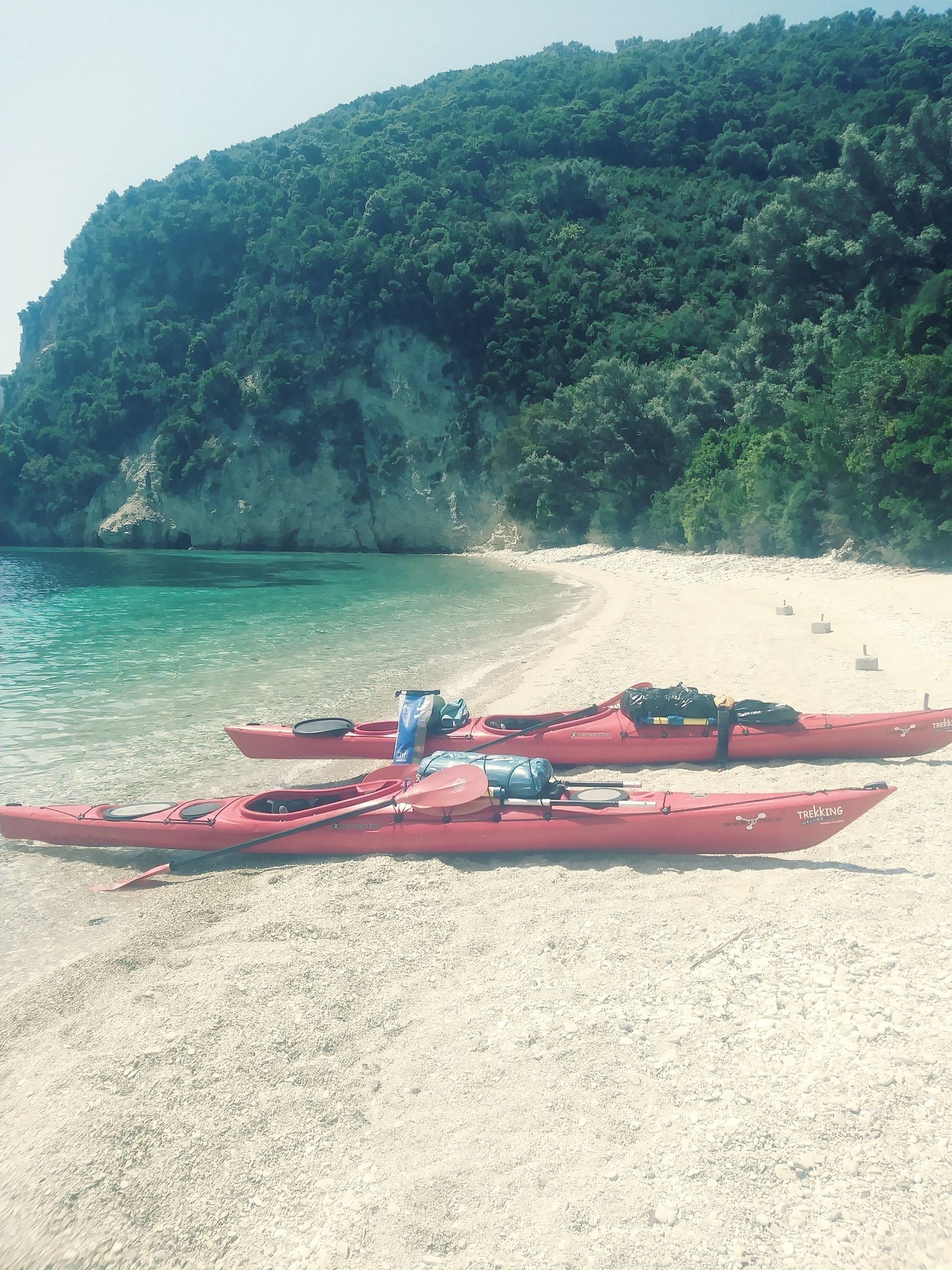 Sea kayaks pulled ashore on a deserted beach in Greece.