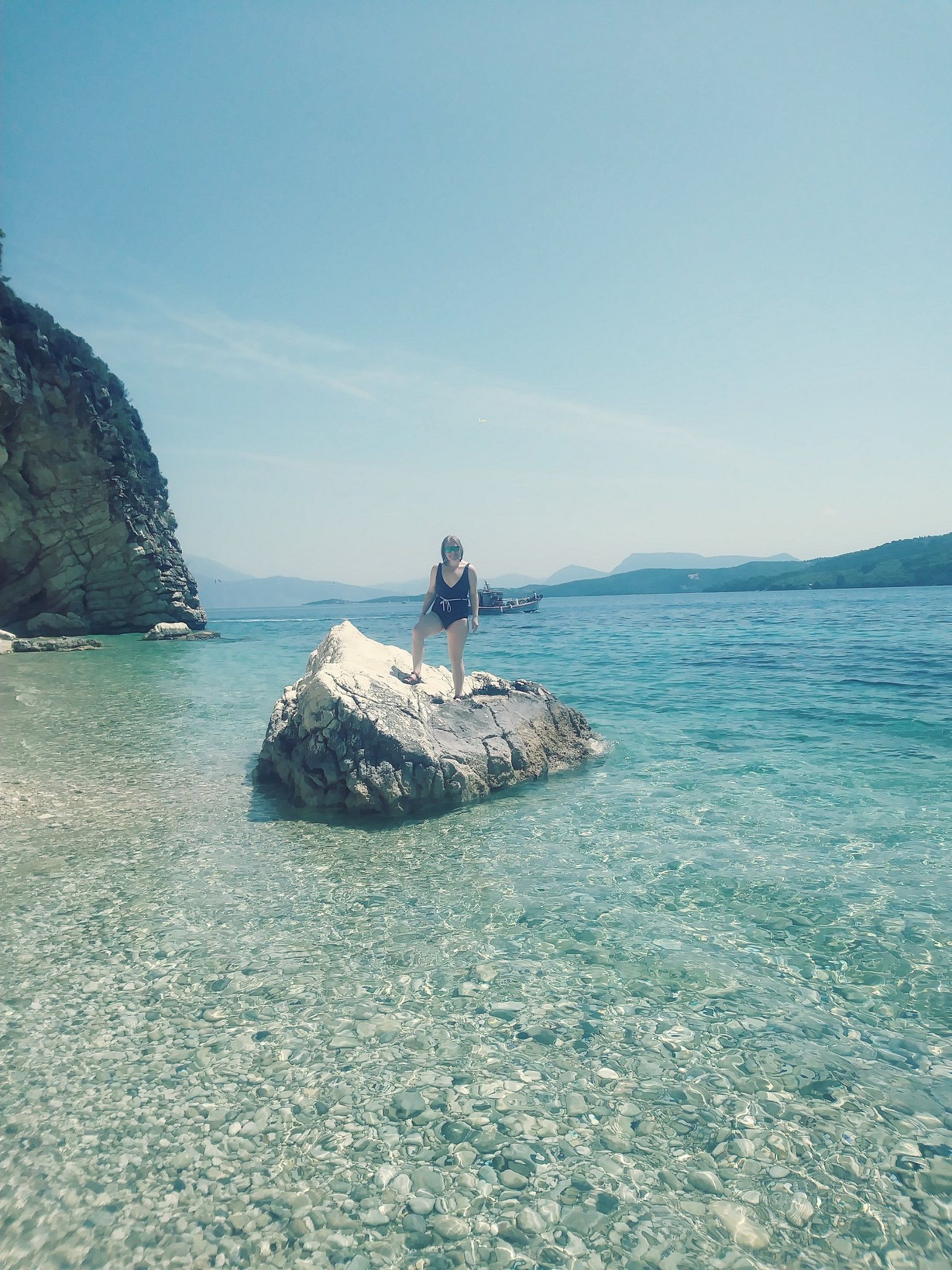 A woman posing on a rock in Lefkada, Greece.