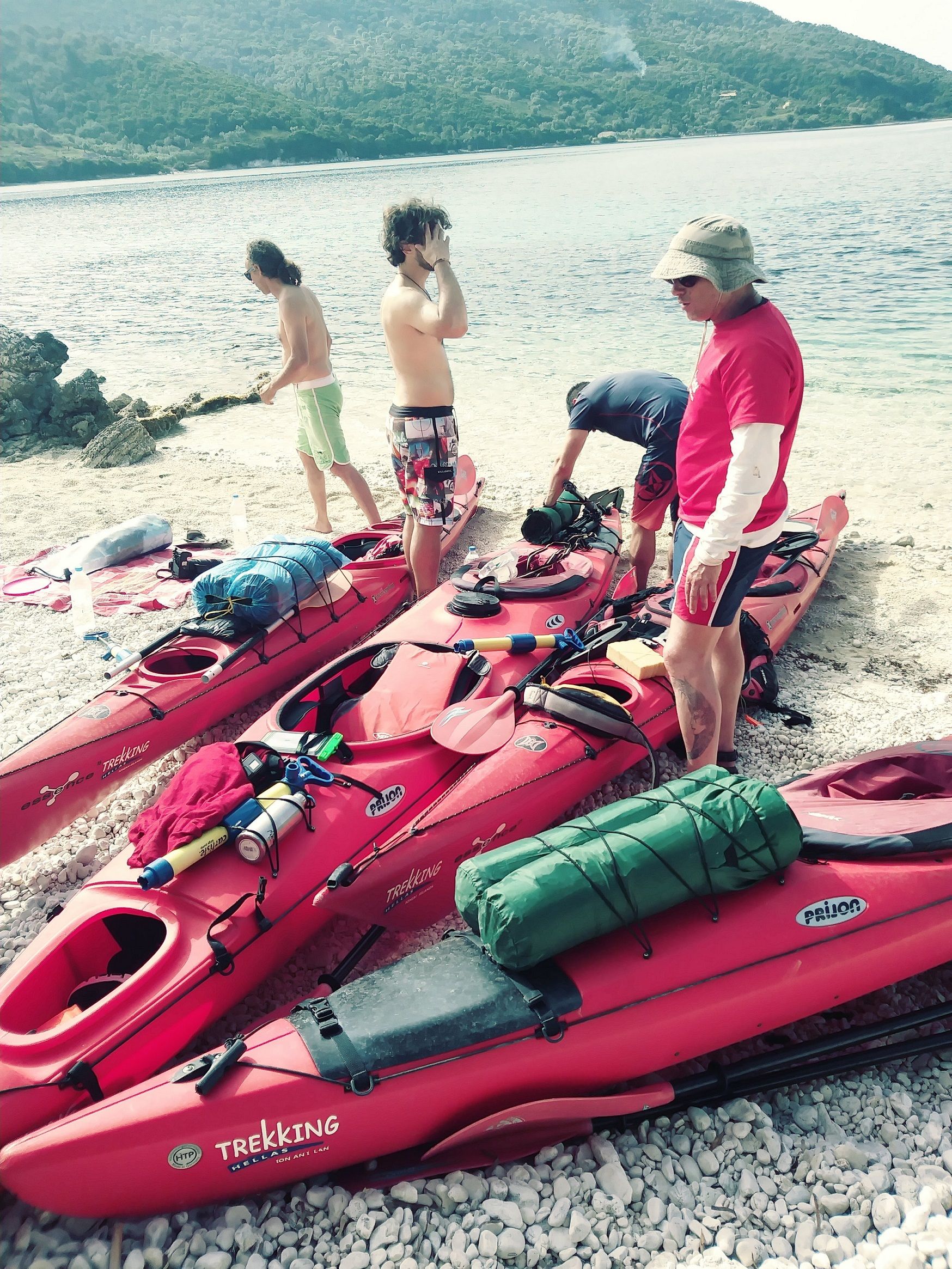 People packing up their kayaks on the beach in Greece