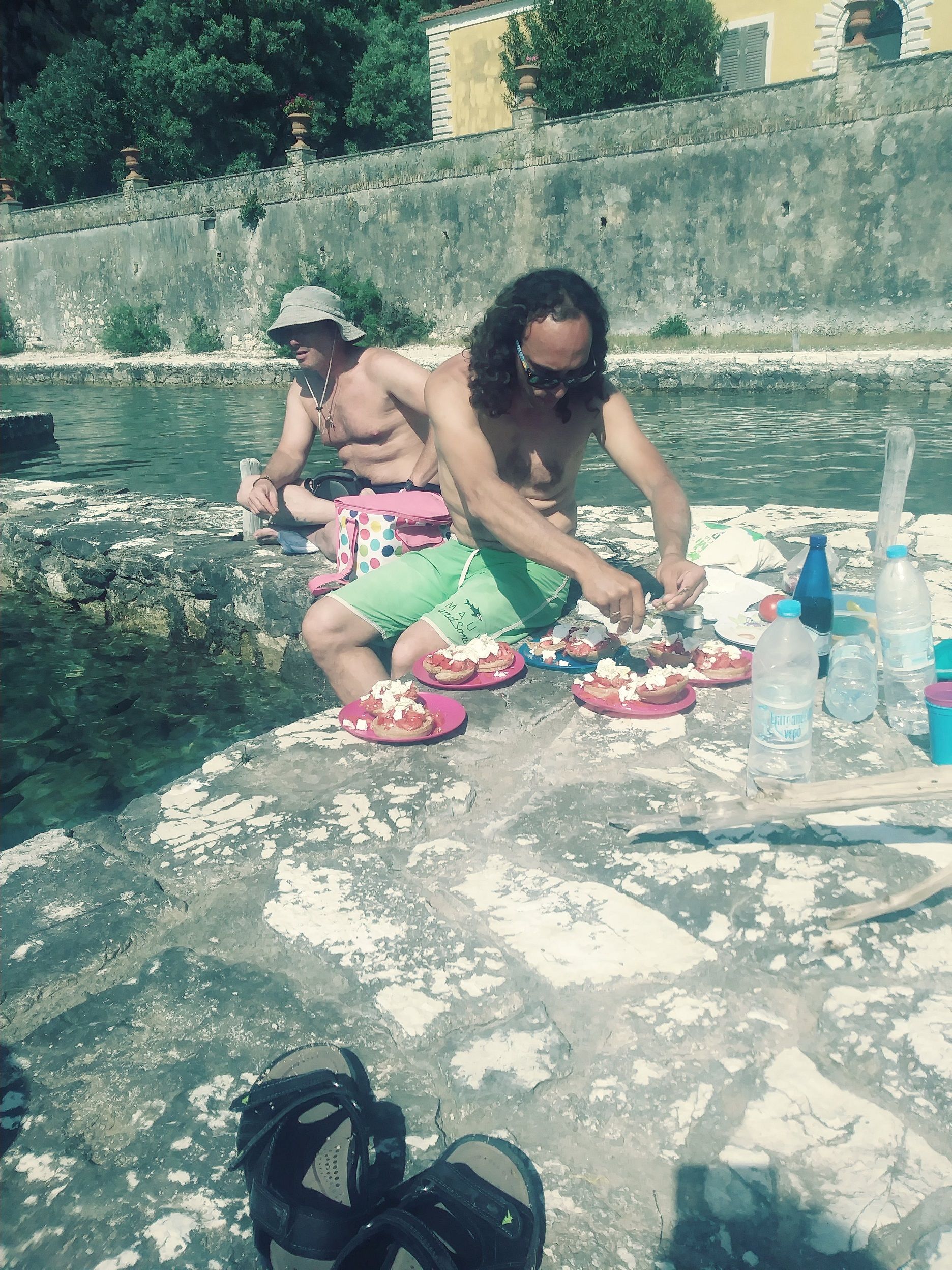 A man makes picnic lunch on an island in Greece.