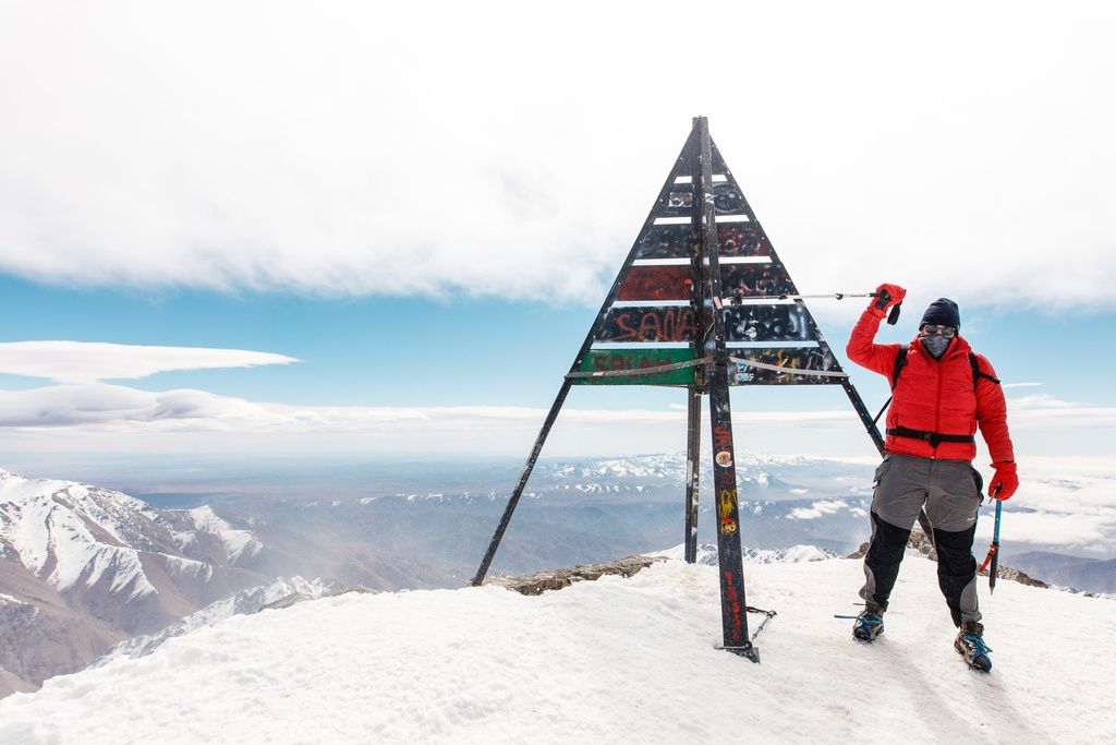 A man Reaching the summit of Mount Toubkal in Winter