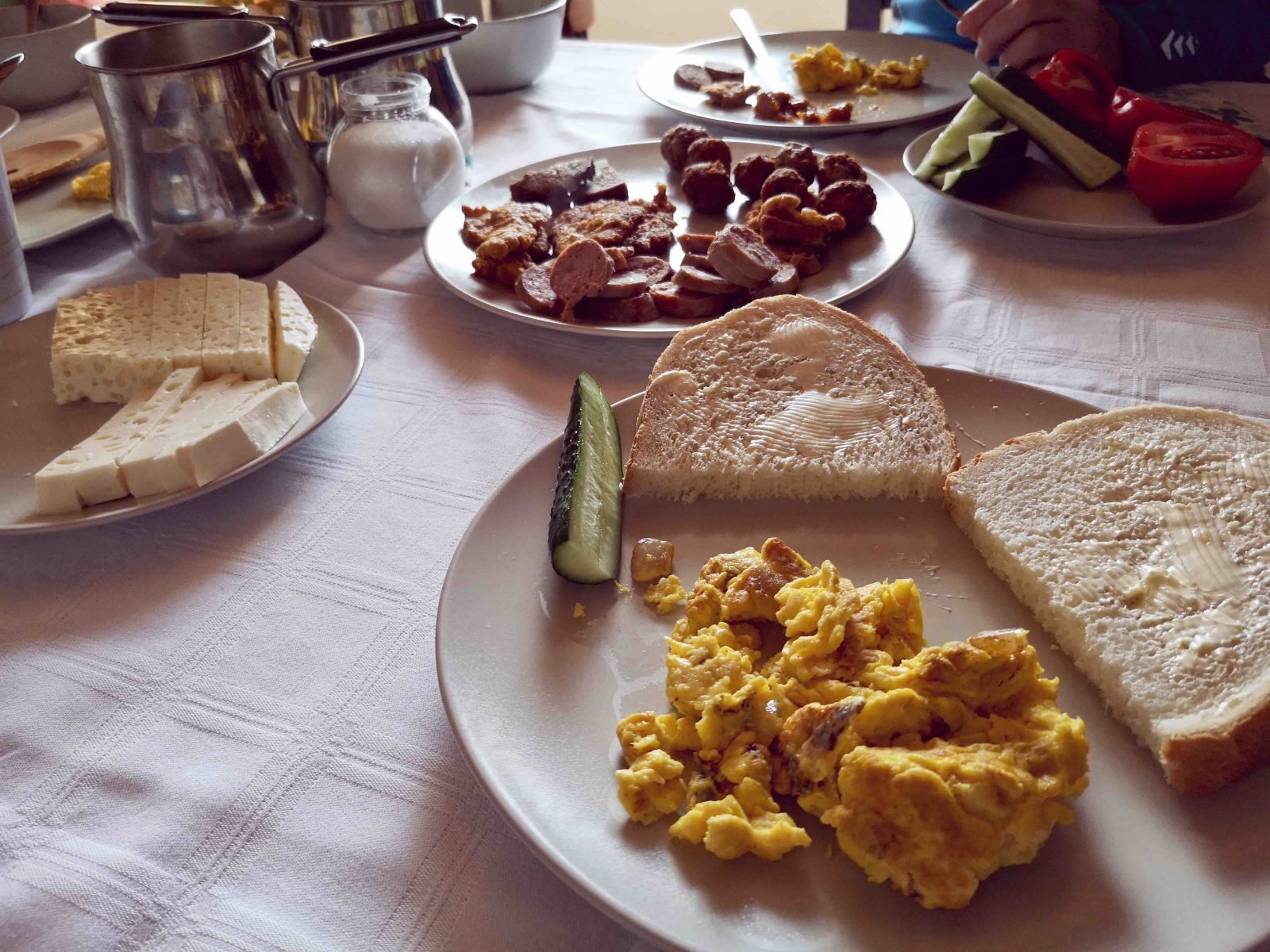 A Romanian breakfast of homemade cheese, homemade bread and butter and scrambled eggs with pig fat.