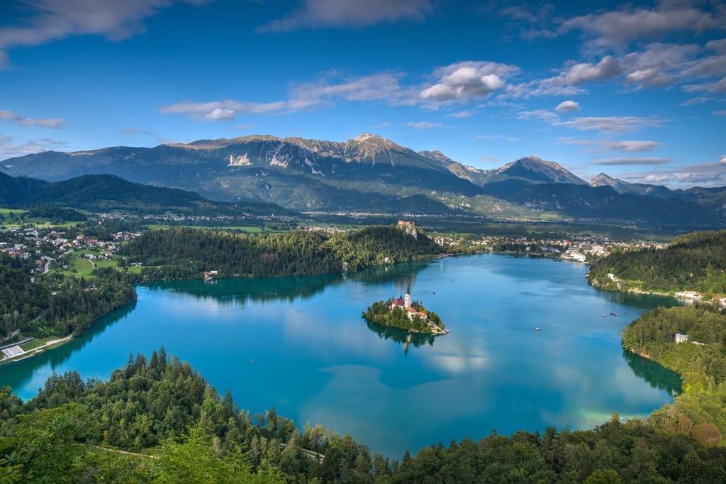 Lake Bled in Slovenia, with a church on an islet in the middle of the water, and Mount Triglav in the background.