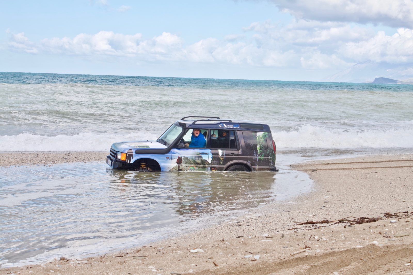 A land rover drives into a river in Albania