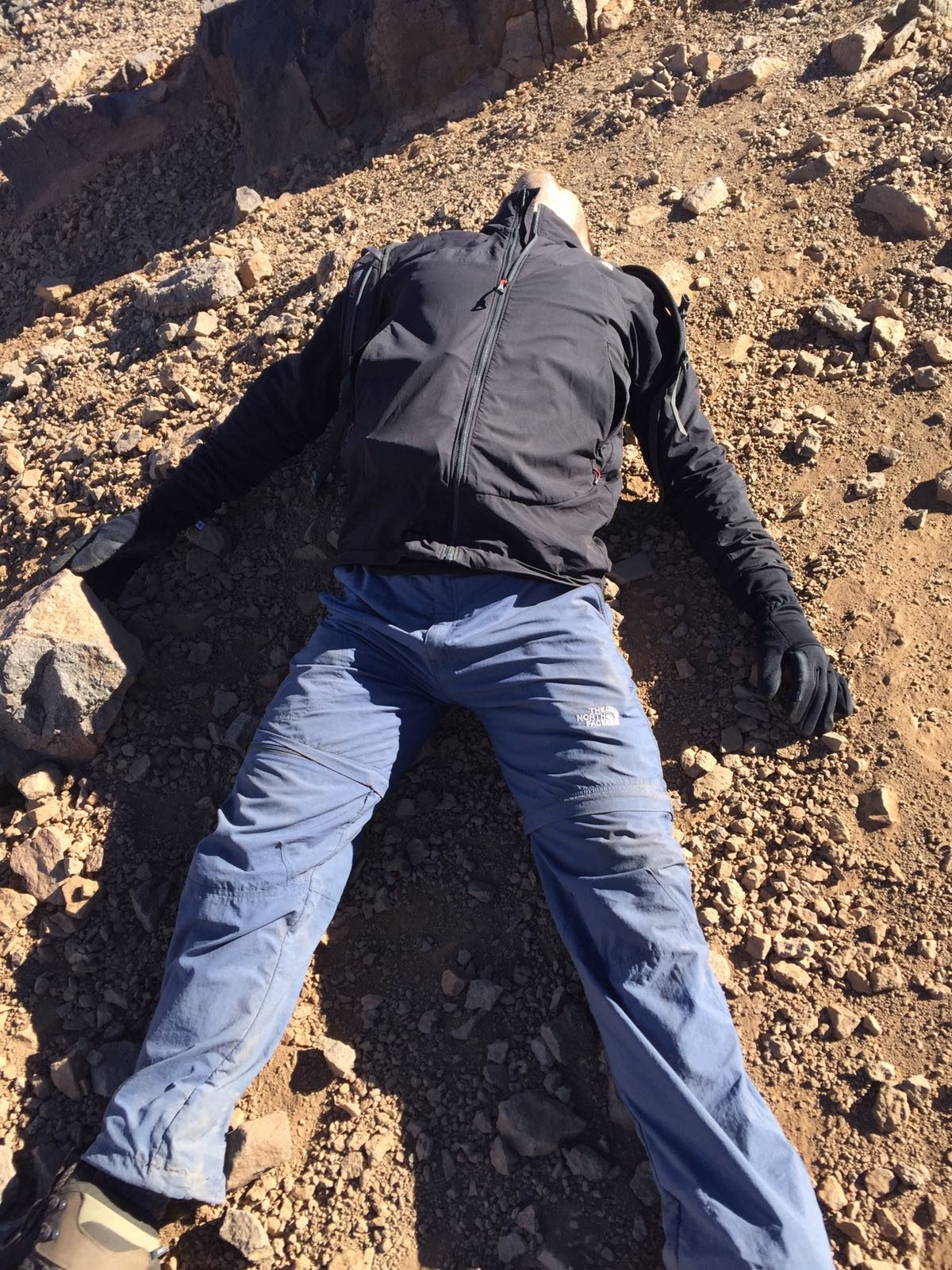 An exhausted hiker collapses on Mount Toubkal.
