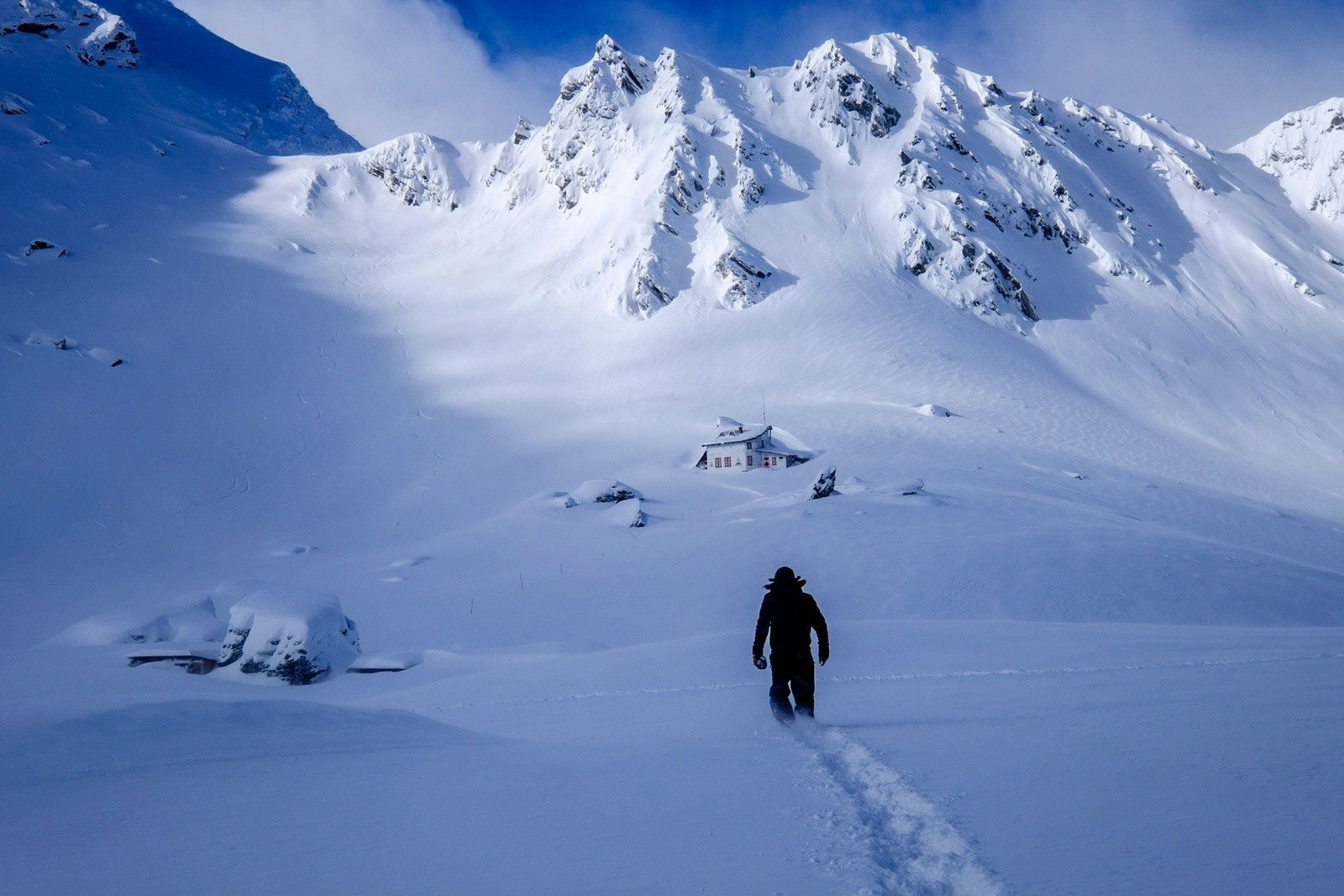A hiker knee-deep in snow in Romania's Carpathian Mountains.
