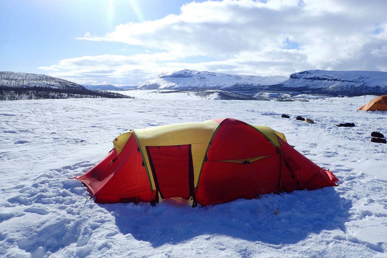 tent-arctic-circle-norway A tent in the Arctic circle, surrounded by snow and mountains.