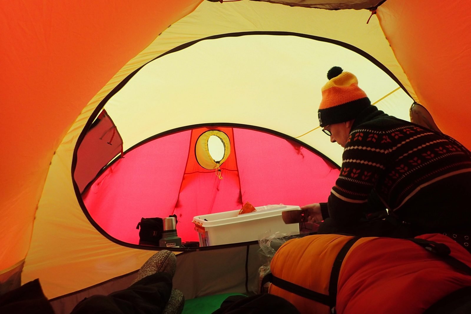 A camper making morning coffee in his tent.