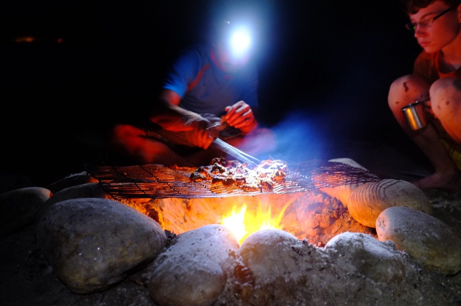 Grilling dinner over the campfire.